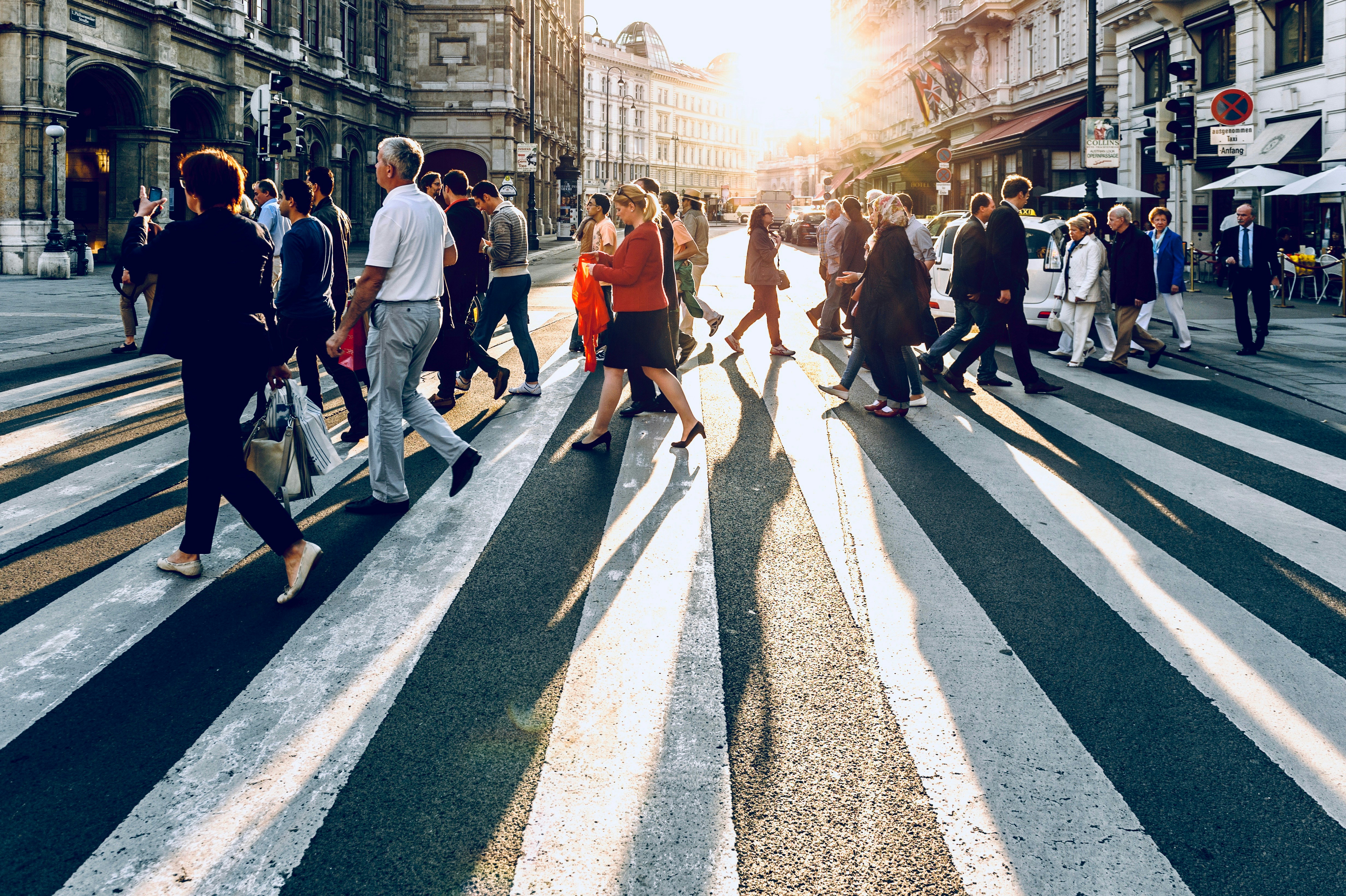 People crossing a city street in low winter light