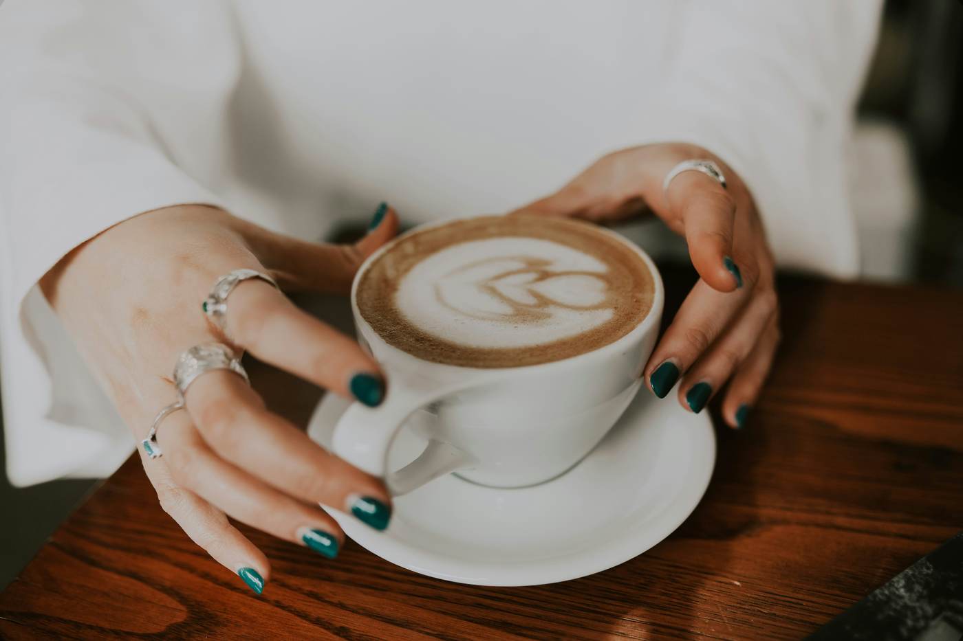 Hands around a coffee cup in morning light